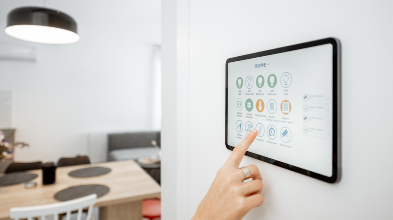 A women using an iPad to control the home security system
