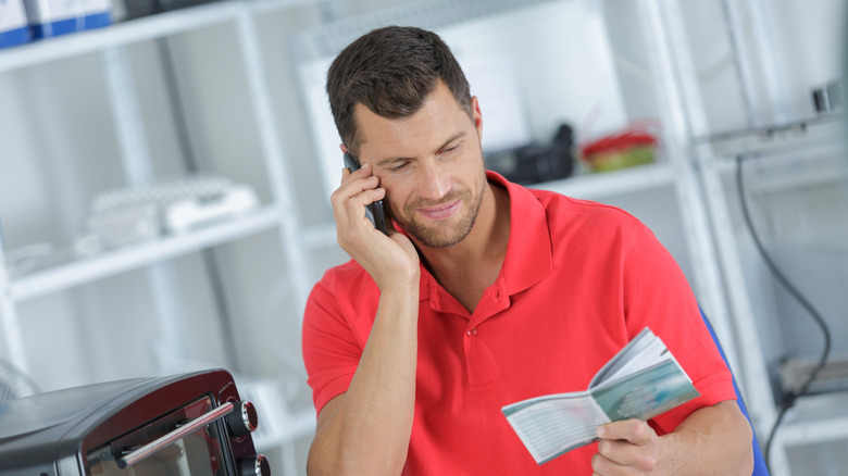 man reads warranty from manual