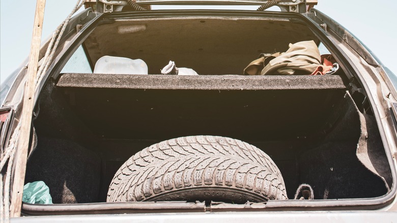 spare tire hanging out of a trunk