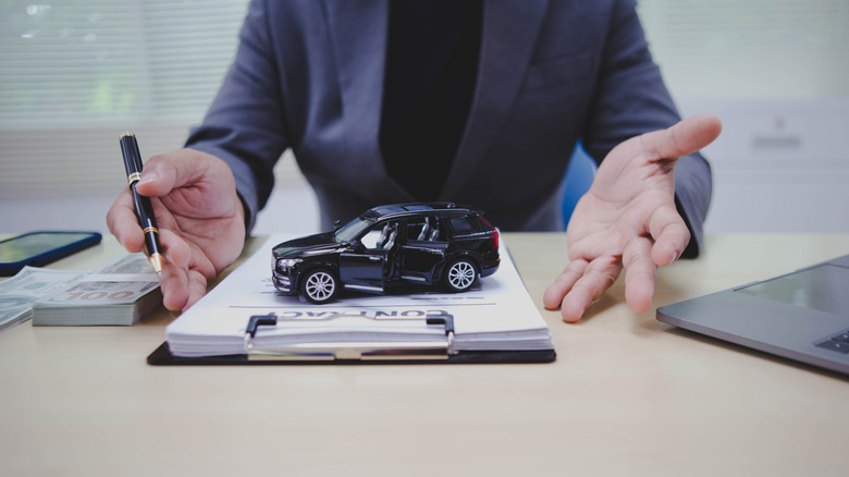 car figure on a clipboard and documents
