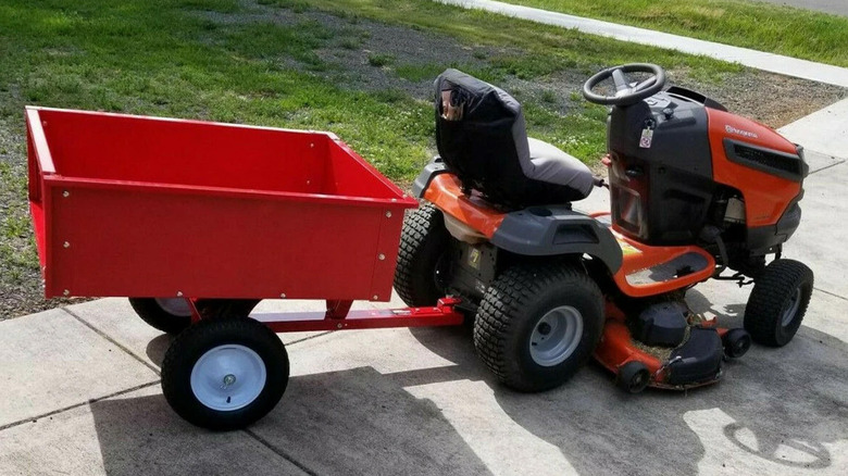 A riding mower with a trailer hitched onto the back
