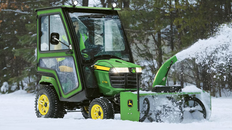 A John Deere riding mower with a snow blower attachment