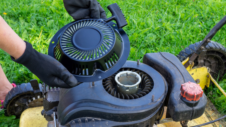 Person repairing lawn mower