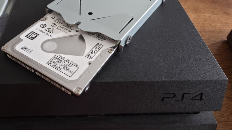 HDD hard drive resting on top of PlayStation 4 console