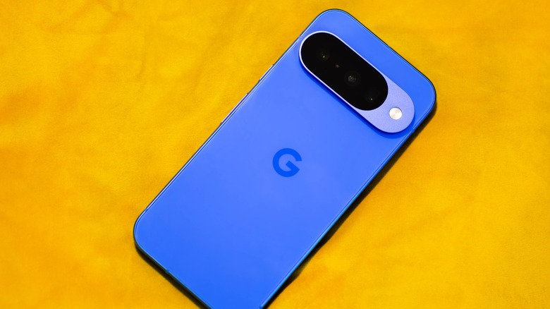 An indigo color Google Pixel 10 phone on a yellow background.