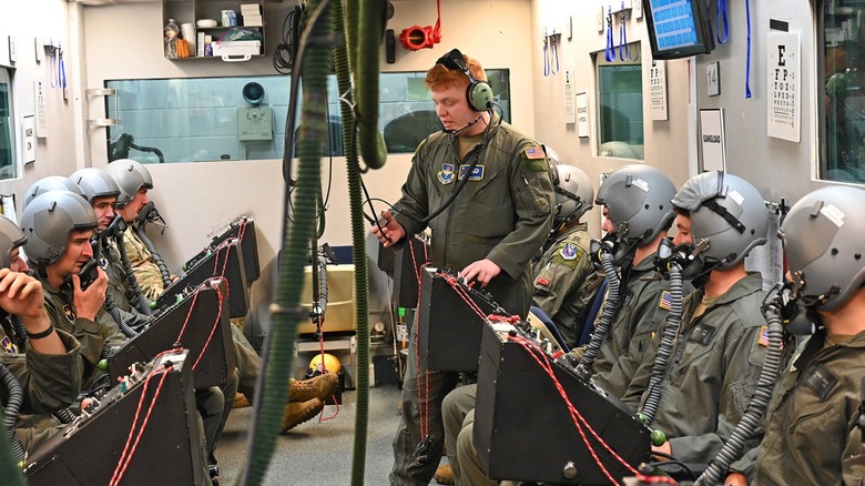 Student USAF pilots receive instructions in an altitude chamber.