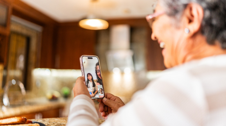 Senior woman talking to family on video call while at home.