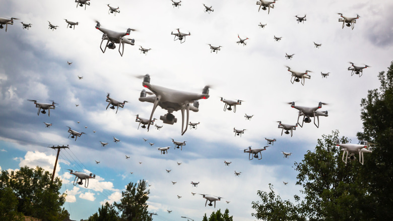 A drone swarm flying over a wooded area