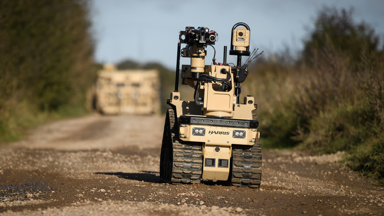 An EOD robot rolling down an unpaved road.