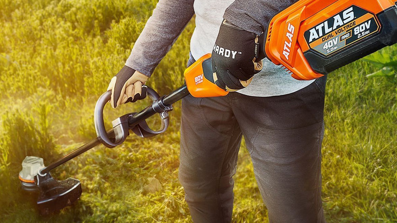 person using atlas weed eater