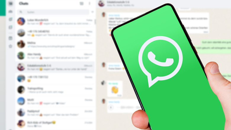 WhatsApp logo on an Android phone with WhatsApp desktop opened in the background