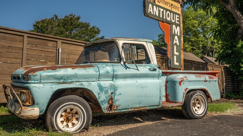 An old pickup truck with wheel bearings that are presumably still good, although the front tire is flat.