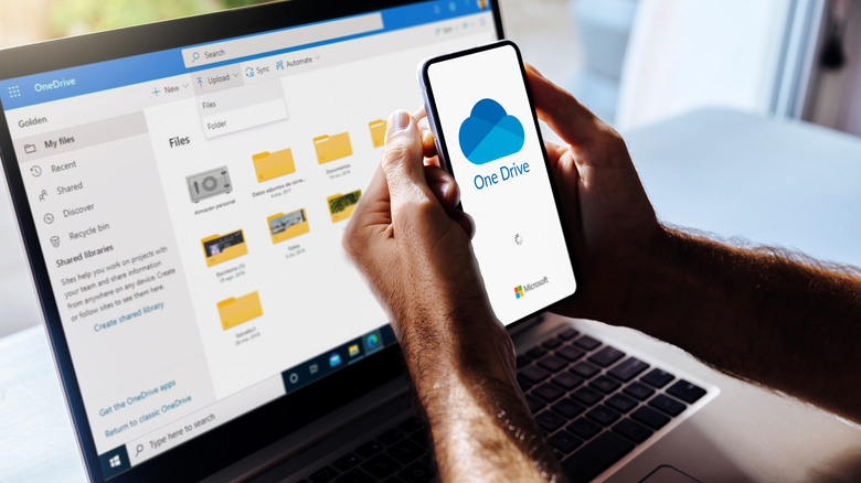 Person using OneDrive on a smartphone and a laptop