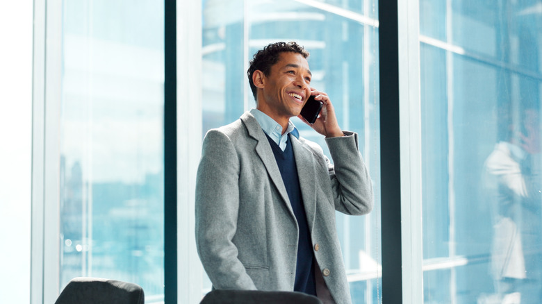 A businessman talking in the phone in a glass-windowed office