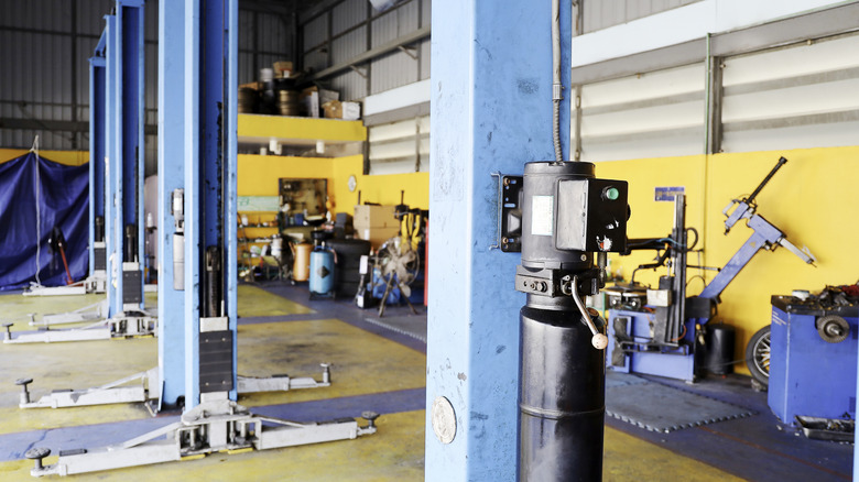 Multiple vehicle lifts in a garage with other tools in the background