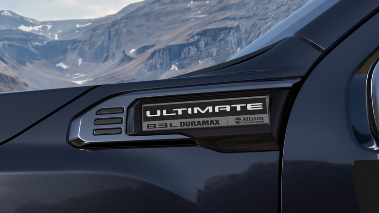 Close-up of the GMC 8.3-liter Duramax badge with a mountain in the background