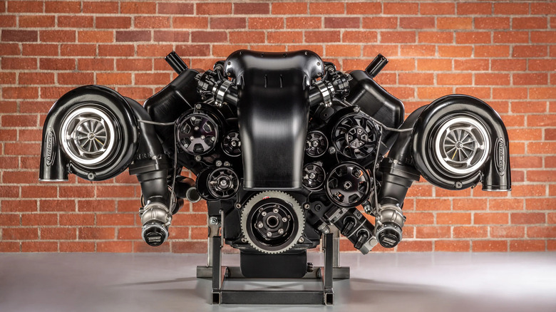 Nelson Racing Engines twin-turbo 572 Hemi engine on a stand in front of a brick wall