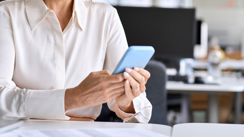 Woman using phone on work desk