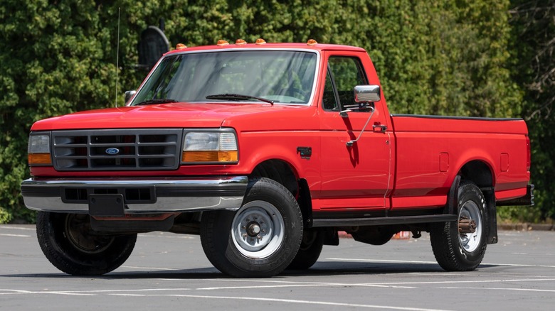 A red Ford pickup sporting the original 7.3L Power Stroke on a parking lot, front 3/4 view