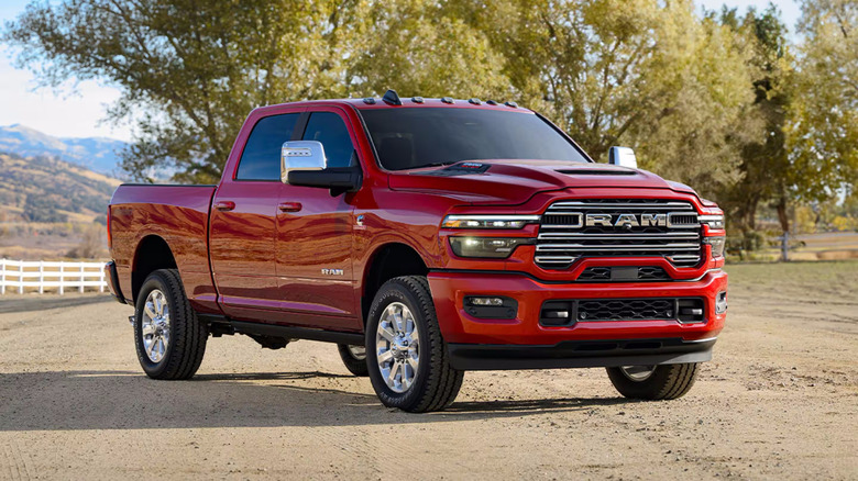 Red Ram 2500 on dirt road with trees in background
