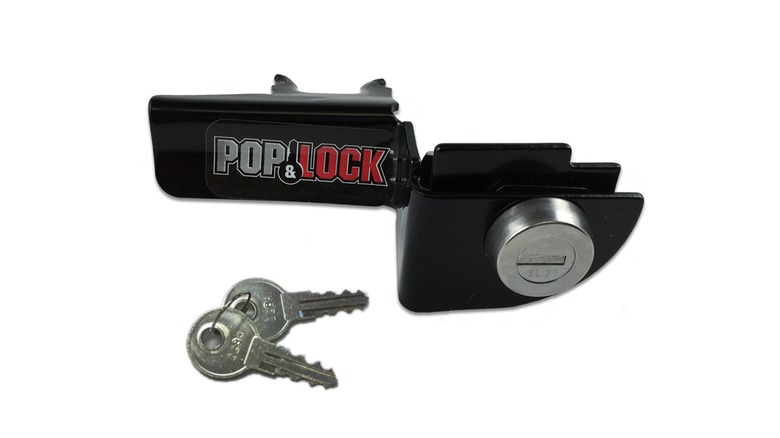 A Pop & Lock manual tailgate lock next to a pair of keys