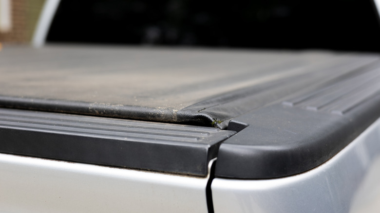 A closeup of a tonneau cover on a white pickup truck