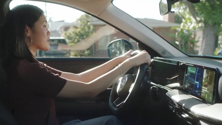 A woman driving is using android auto