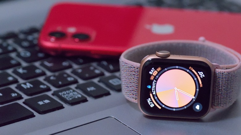 pink Apple Watch on laptop with red iPhone
