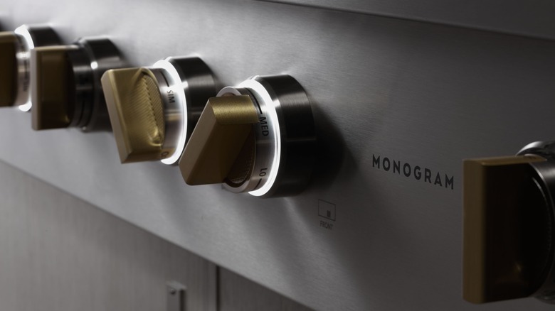 close-up of Monogram logo and illuminated knobs on a Monogram cooking range