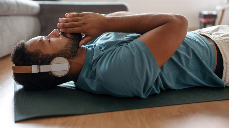 man lying down listening to headphones
