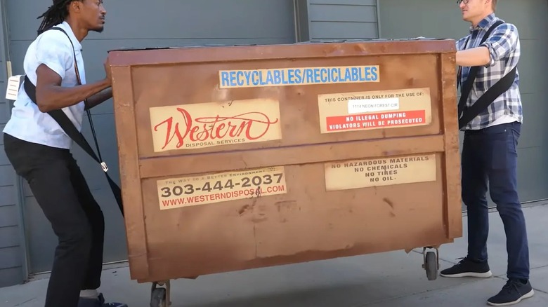 two people carrying a dumpster using the Shoulder Dolly