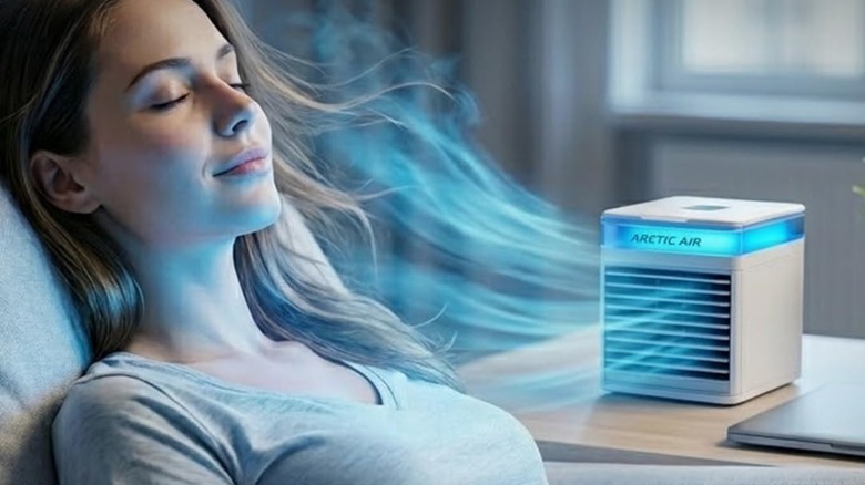 A woman using an Arctic Air Pure Chill 2.0 air-conditioner to produce cool air
