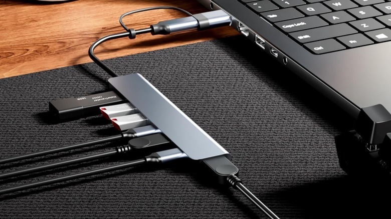 A BERLAT USB-C/USB hub connected to a laptop with multiple devices plugged in