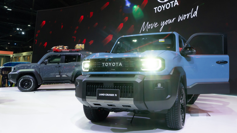 Blue and gray Toyota Land Cruiser FJ SUVs on display at auto show.