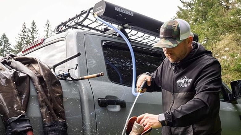 Man using pressurized water tube from truck 