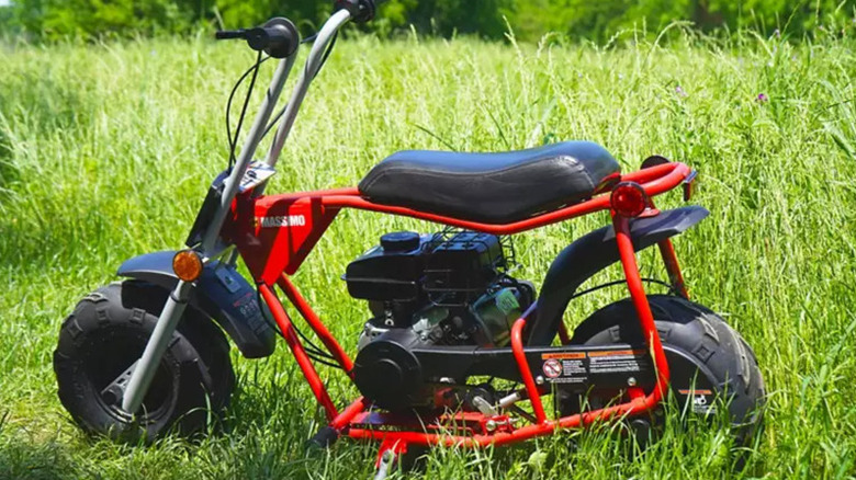 left side view of Massimo B100 mini bike parked in grass field