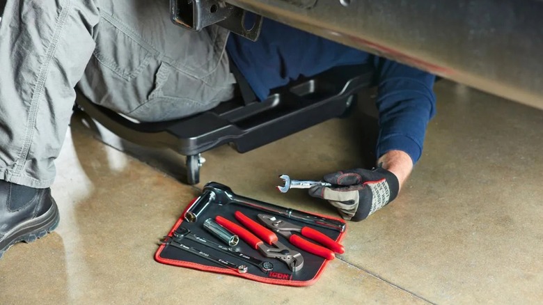 Mechanic using Icon Magnetic Tool Mat while under vehicle