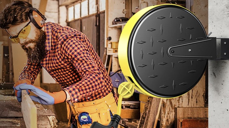 Dewenwils Retractable Extension Cord Reel mounted as a woodworker works in their garage