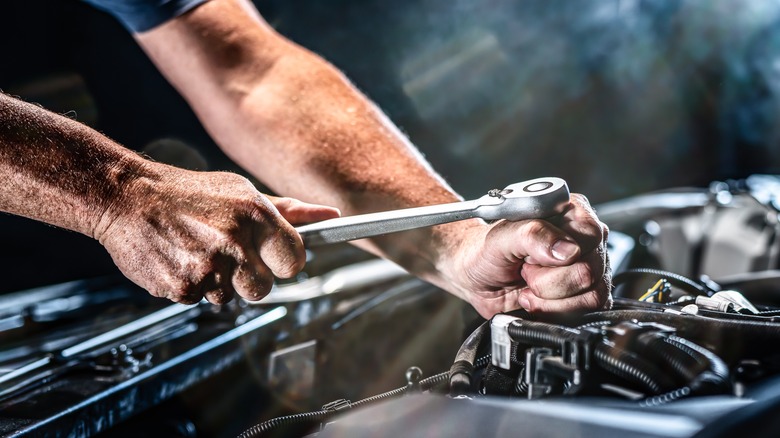 Hands working on car engine