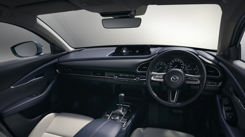 The interior of a right-hand drive 2019 Mazda CX-30 subcompact SUV, finished here in a dark black shade.