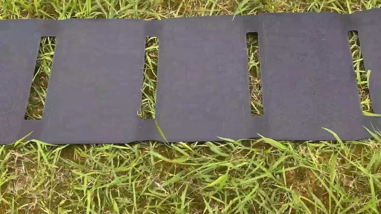 Solar panels laid out on the grass on a sunny day