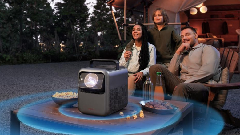 Group of people sitting outside and watching the Anker Nebula X1 projector