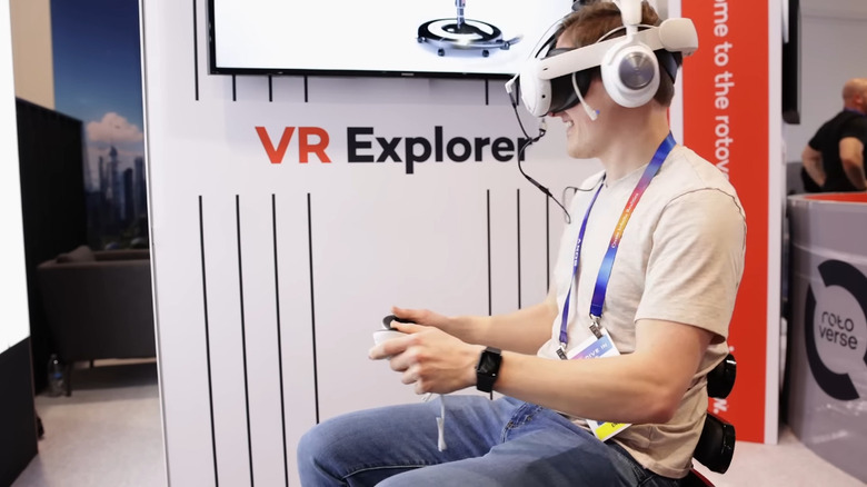 A man sitting on the Roto VR Explorer chair playing a VR game