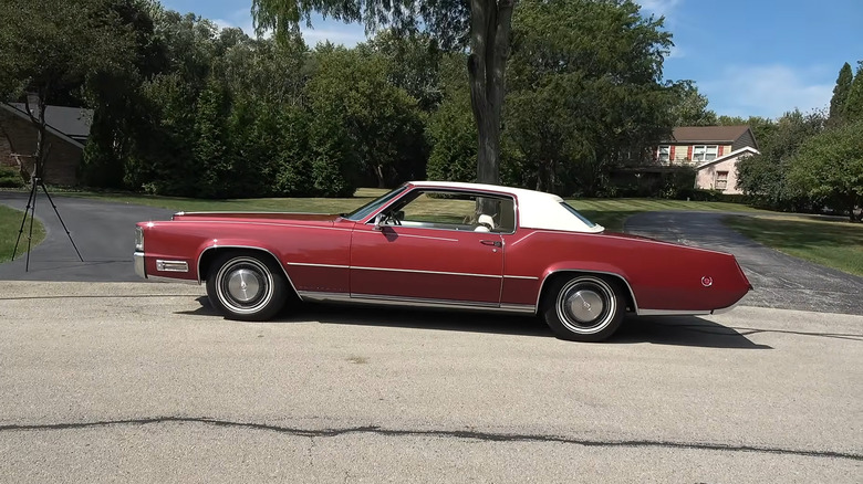 A red 1970 Cadillac Eldorado parked at the side of a paved road.