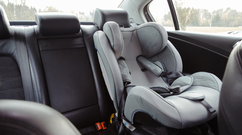 A child seat for safety mounted to the second row of an unidentified car as seen from the inside