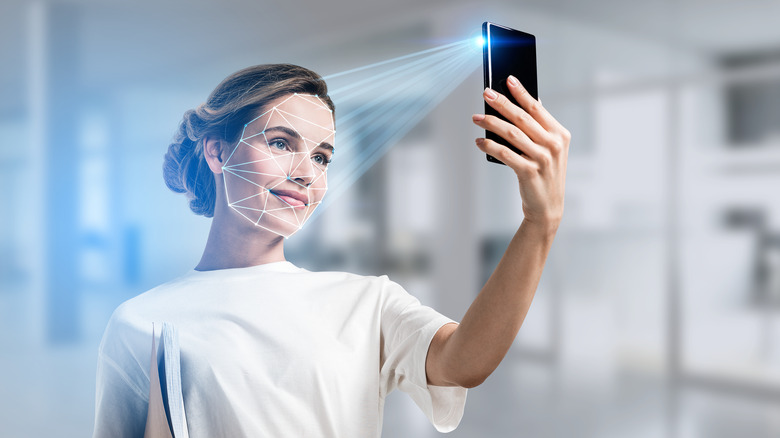 Woman using face unlock on smartphone