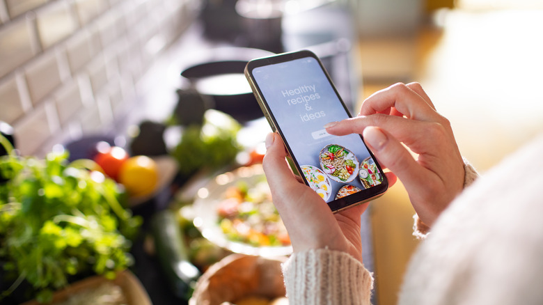 woman checking recipe on phone
