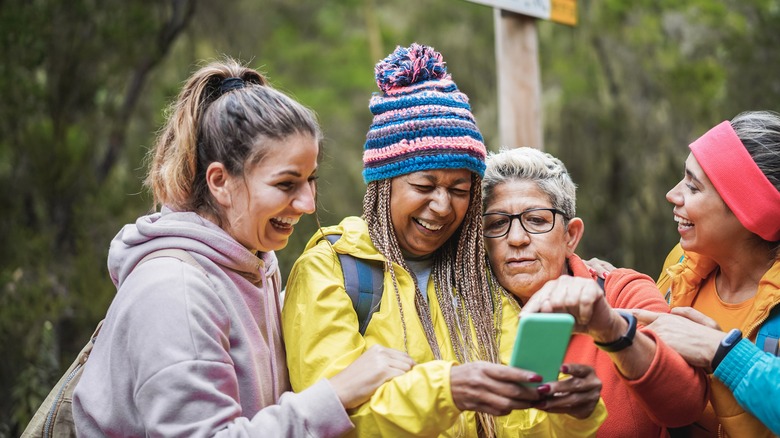 women using mobile phone maps on hike