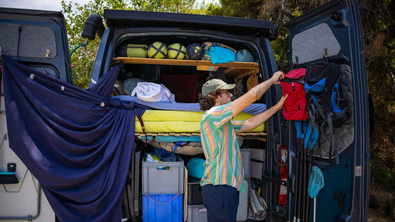 A man efficiently packing his campervan.