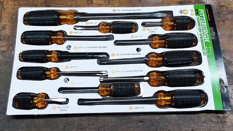 set of orange and black screwdrivers in package on a workbench